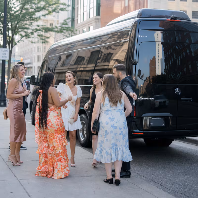 Group boarding a white charter bus for Bachelor & Bachelorette Transportation transportation in Grand Rapids