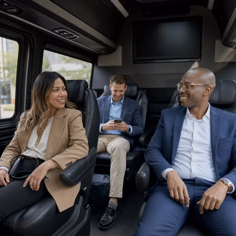 Group boarding a white charter bus for Corporate Transportation transportation in Grand Rapids