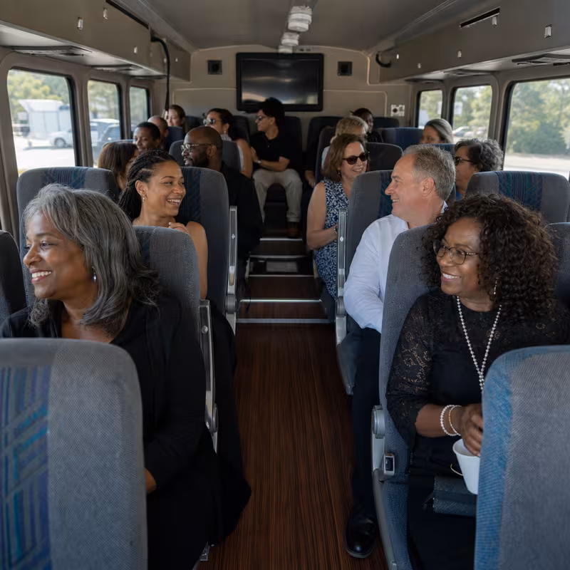 Group boarding a white charter bus for Private Event Transportation transportation in Grand Rapids