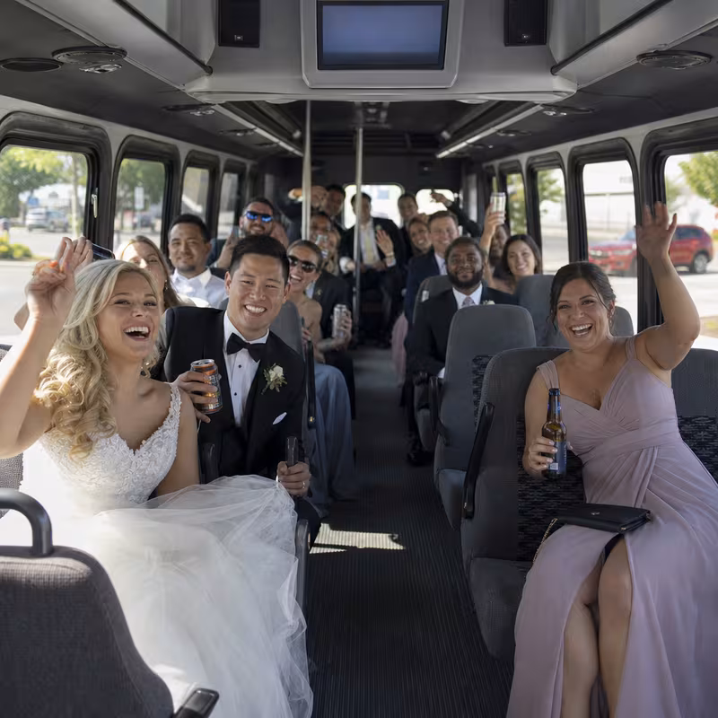 Group boarding a white charter bus for Wedding Transportation transportation in Grand Rapids